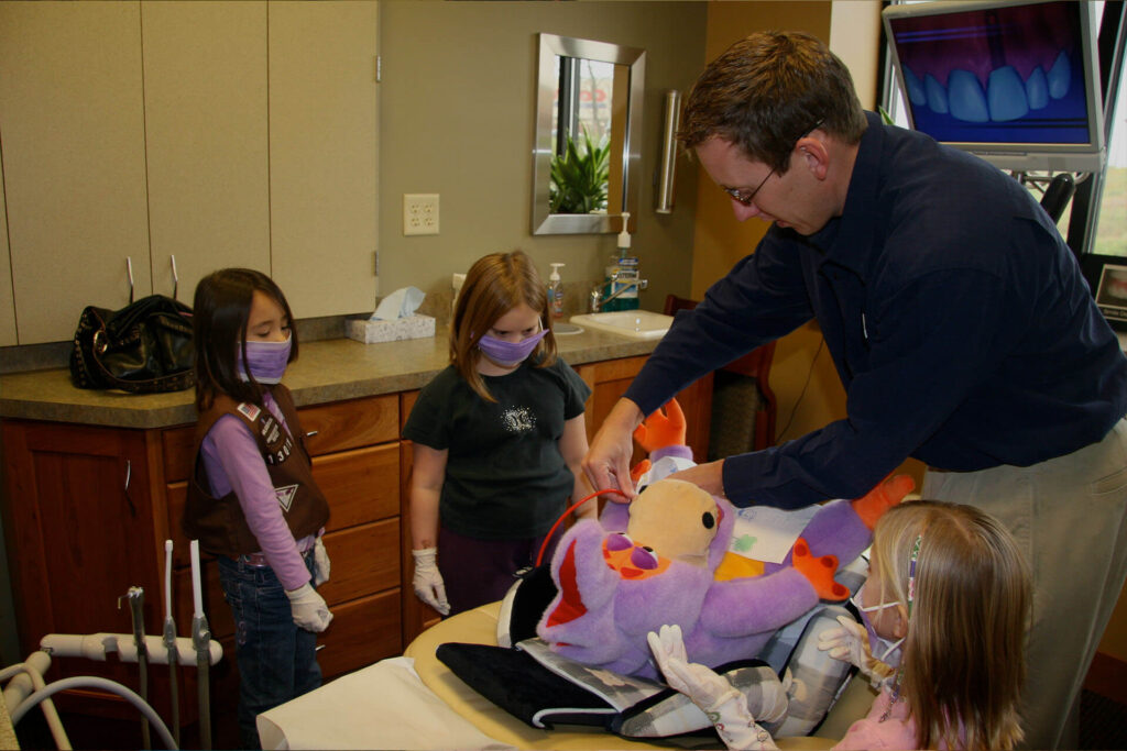 dr kevin molldrem holding a toy with 3 kids