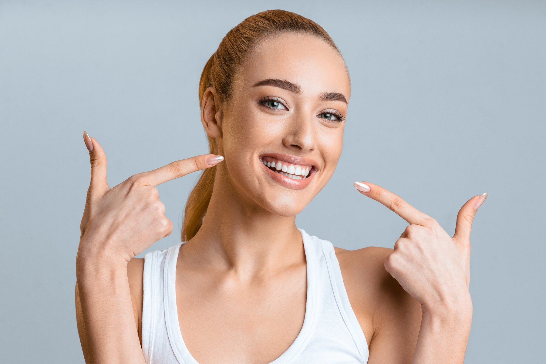 Woman pointing to her smile