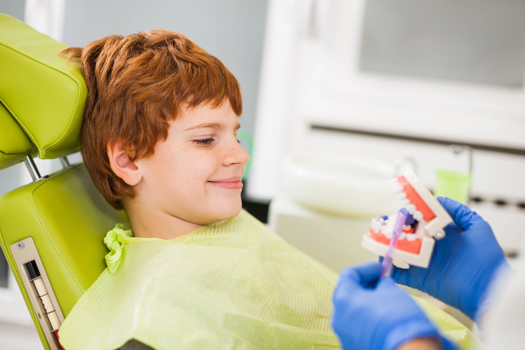 Dentist teaching a child about oral hygiene