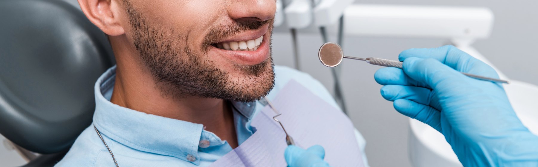 Dentist holding dental instruments near a patient